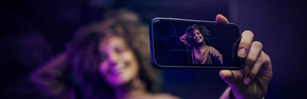 Young woman taking a selfie. Dramatic purple lighting