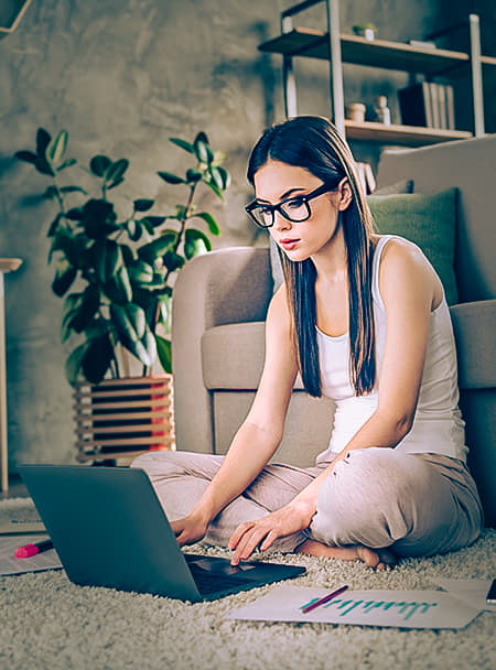 woman sitting on floor working with laptop